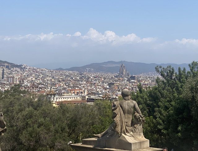 Una estatua de piedra aparece ante el perfil urbano de Barcelona, con la Sagrada Familia entre los edificios.