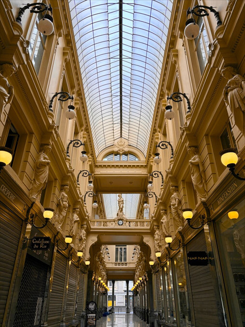 Las Galerías Reales Saint-Hubert de Bruselas alinean escaparates cerrados y esculturas bajo una cubierta acristalada.