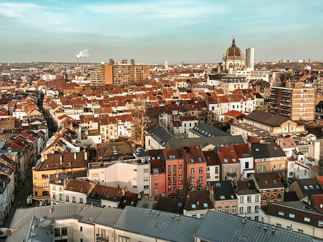 Los tejados rojizos de Bruselas se extienden hacia una gran basílica con cúpula, entre bloques residenciales y campanarios.