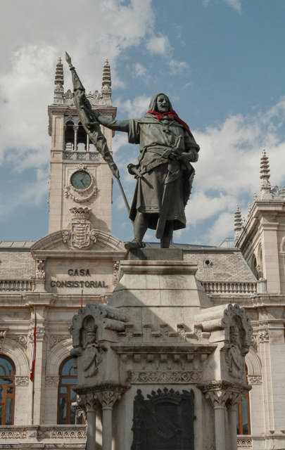 Estatua de bronce con pañuelo rojo y estandarte, vista desde abajo ante la Casa Consistorial de Valladolid.